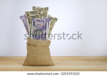 Rupees 100 and 500 notes in a jute sack. Royalty-Free Stock Photo #2203591021