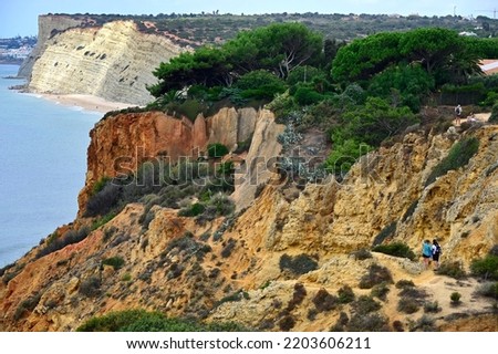 Lagos, Algarve, Portugal, Europe - GeologicaL - landscape trail of Ponta da Piedade for walks and cycling only, unique geological formations, fauna and flor, Porto de Mos beach in background Royalty-Free Stock Photo #2203606211