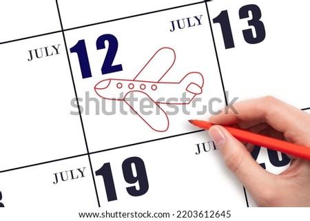 12th day ofJuly. A hand drawing outline of airplane on calendar date 12 July. The date of flight on plane. Travel, business trips. Summer month. Day of the year