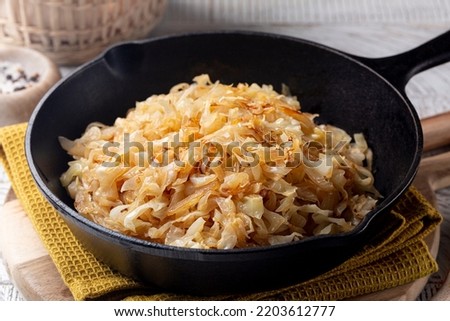 Quick Pan fried Sauerkraut or Crauti. Finely cut white cabbage cooked with fried onion and white wine. Close-up. Royalty-Free Stock Photo #2203612777