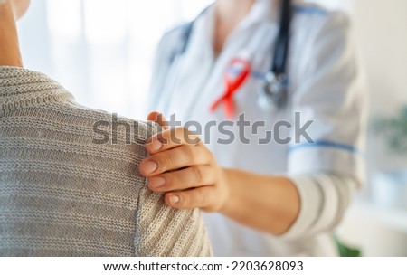 Pink ribbon for breast cancer awareness. Female patient listening to doctor in medical office. Support people living with tumor illness. Royalty-Free Stock Photo #2203628093