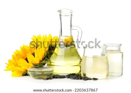 Oil, seeds and sunflowers on white background