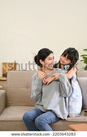 Portrait, Lovely Asian mom and little young daughter playing, relaxing and spending time together in their living room. Royalty-Free Stock Photo #2203643283