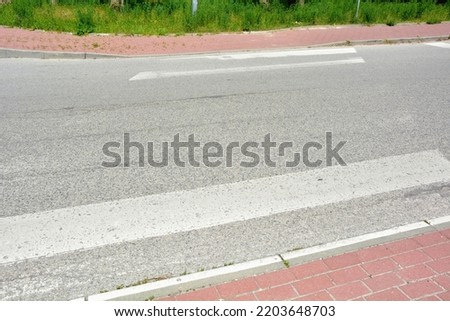 Worn pedestrian crossing lanes on the road