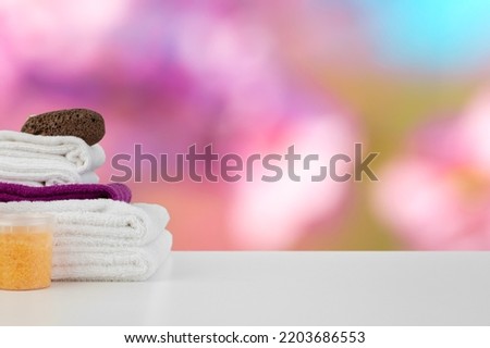 Spa still life with towels and skincare cosmetics against blurred background