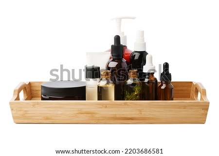Set of cosmetic dark glass bottles on wooden stand