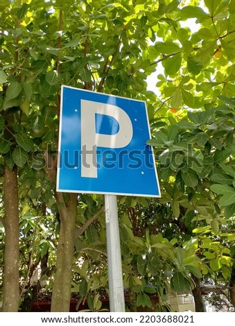 parking sign installed outside the room that is almost covered with leaves