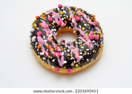 glazed donut with colorful sprinkles close-up on a white background