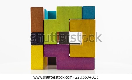 Cube made of multicolored wooden figures on a white background. Concept of logical thinking.