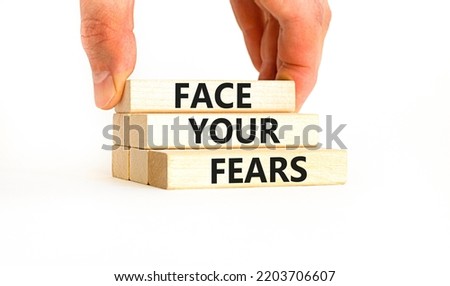 Face your fears and support symbol. Concept words Face your fears on wooden blocks. Businessman hand. Beautiful white table white background. Business and Face your fears quote concept. Copy space.