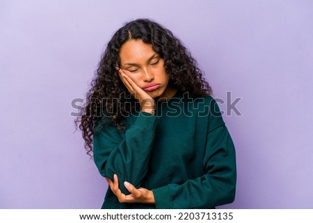 Young hispanic woman isolated on purple background who is bored, fatigued and need a relax day.