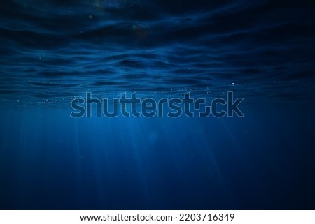 ocean underwater rays of light background, under blue water sunlight Royalty-Free Stock Photo #2203716349