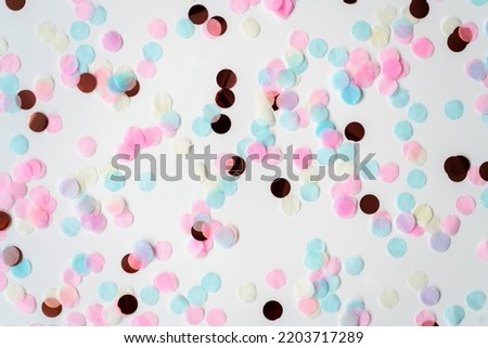 Blue and pink round confetti on white background. Festive day backdrop. Flat lay style with minimalistic design. Template for banner or party invitation