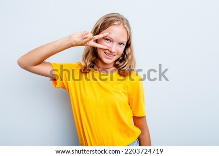 Caucasian teen girl isolated on blue background dancing and having fun.