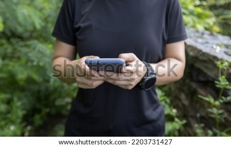 Hands using mobile phone  in summer forest