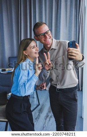 Happy business colleagues working together in the office and using the phone. Colleagues take a selfie during a break