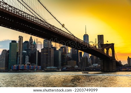 Sunset view of Brooklyn Bridge and panoramic view of downtown Manhattan in New York City, USA