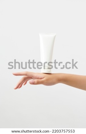 cosmetics white tube on the back of a woman's hand. mockup concept.  Royalty-Free Stock Photo #2203757553