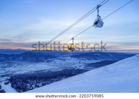 View from mount peak on Sheregesh ski resort and Altai mountains or Gornaya Shoria. Active winter rest, skiers and snowboarders on ski slope and Ski lift, beautiful nature and sport leisure.  Royalty-Free Stock Photo #2203759085