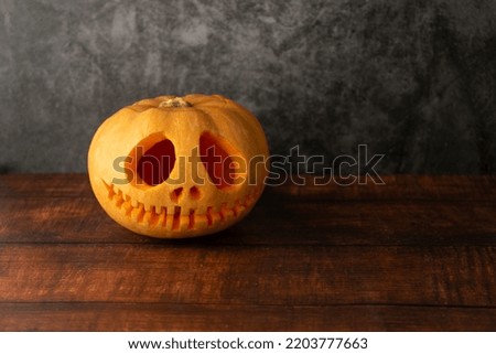 pumpkin on top of a wooden table with a dark background
