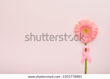 Pink Breast Cancer Awareness Ribbon. Gerbera and pink ribbon on backgrounds. Breast cancer awareness and October Pink day, world cancer day. Top view. Mock up. Royalty-Free Stock Photo #2203778885