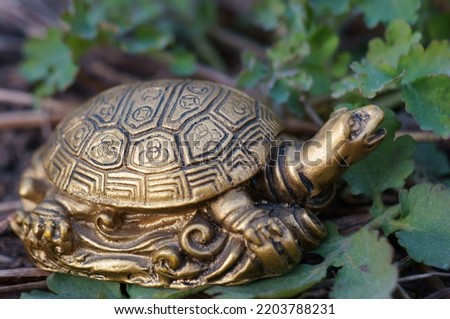 A metal turtle on a background of green grass.