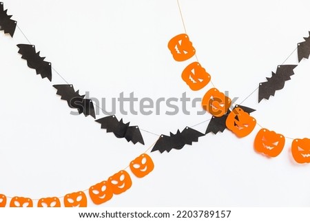 Trick or Treat concept. Holiday composition with halloween garland decorations pumpkins and bats isolated on white background. Preparation for Halloween party. Autumn fall happy Halloween.