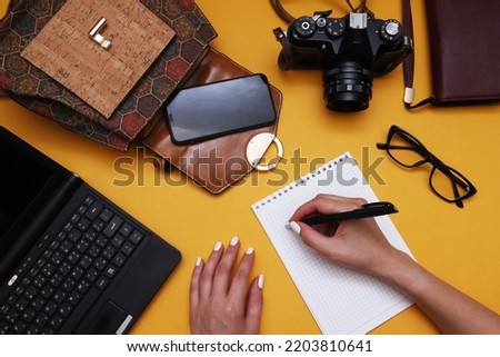 Photojournalist or photographer workplace with film camera, optical glasses and camera accessories, travel essentials.