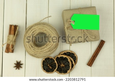 Tag on a box with a gift, tied with a rope. Paper parcel wrapped with a price tag on a wooden background. Chrome key. copy space