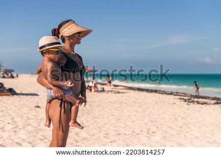 Latin Mom and her baby boy at the beach watching the sea