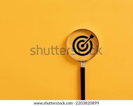 Magnifier focuses on the target icon. Focusing, finding or analyzing business goals and targets concept. Royalty-Free Stock Photo #2203820899
