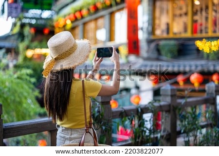 Tourist woman use cellphone to take photo in Jiufen village