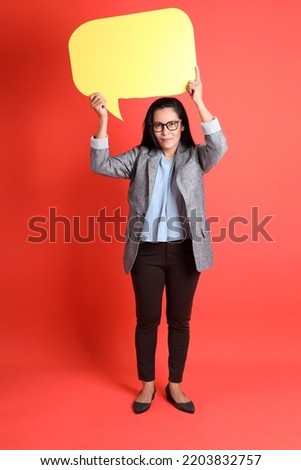 The Asian senior businesswoman standing on the orange background.
