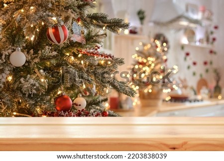 Empty wooden table on the background of christmas tree and blurred christmas kitchen, golden bokeh.Christmas background. Merry Christmas and Happy New Year! Ready for product montage.Mockup.