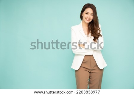 Young Asian business woman smiling with arms crossed isolated on green background