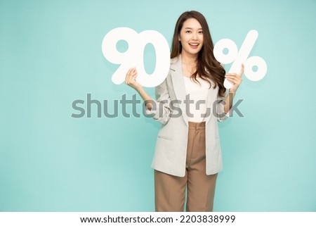 Portrait of Asian business woman standing and holding 90% number or ninety percent isolated on green background