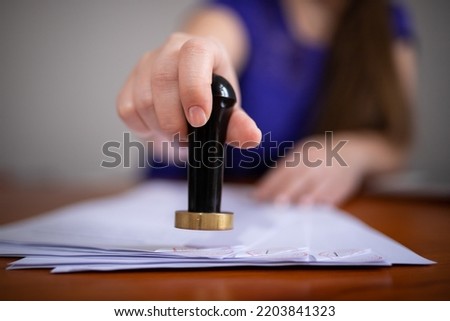 A person puts a seal on a document