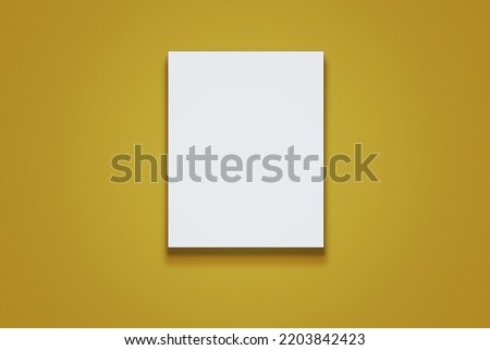 White clean paper sheet lying on yellow surface or hanging on wall