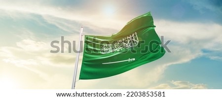 Saudi Arabia national flag waving in beautiful sky. Royalty-Free Stock Photo #2203853581