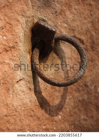 rusty old piton with ring attached in sandstone