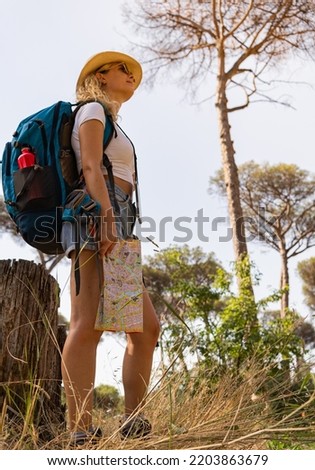Brave woman explores with her map in the middle of the savannah, vertical shot