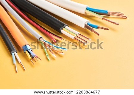 Electric cables, many copper wires with colored isolation isolated on yellow background Royalty-Free Stock Photo #2203864677