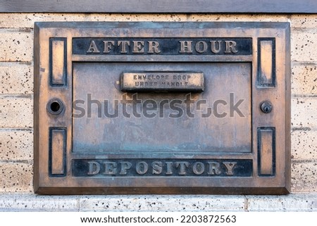 Metal After Hour Depository box attached to brick wall. Royalty-Free Stock Photo #2203872563