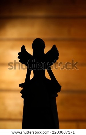 The angel shape against the dramatic lighting background.