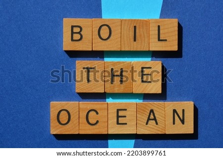Boil The Ocean, business idiomatic phrase meaning to make or undertake an impossible task, in wooden alphabet letters isolated on blue background