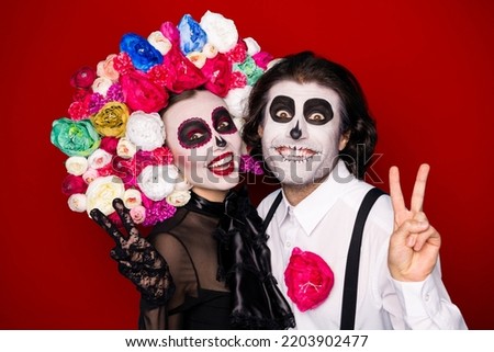 Photo of scary creepy couple man lady cuddle show v-sign make message picture living succesors wear black dress death costume mask rose headband suspender isolated red color background