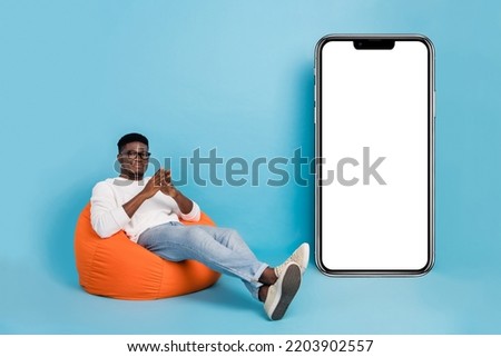 Full body photo of handsome person sitting bag presenting empty space website isolated on blue color background