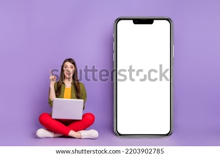Portrait of attractive cheery girl using laptop pointing up copy space ui electronic isolated over violet purple color background