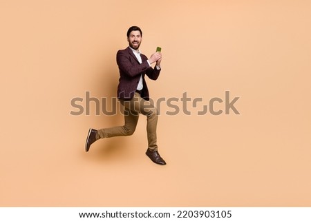 Full body picture of businessman marketing manager chatting with colleagues in phone isolated on beige color background