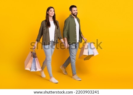 Full body photo of cheerful young girl and man holding hands visit shopping center isolated on yellow color background